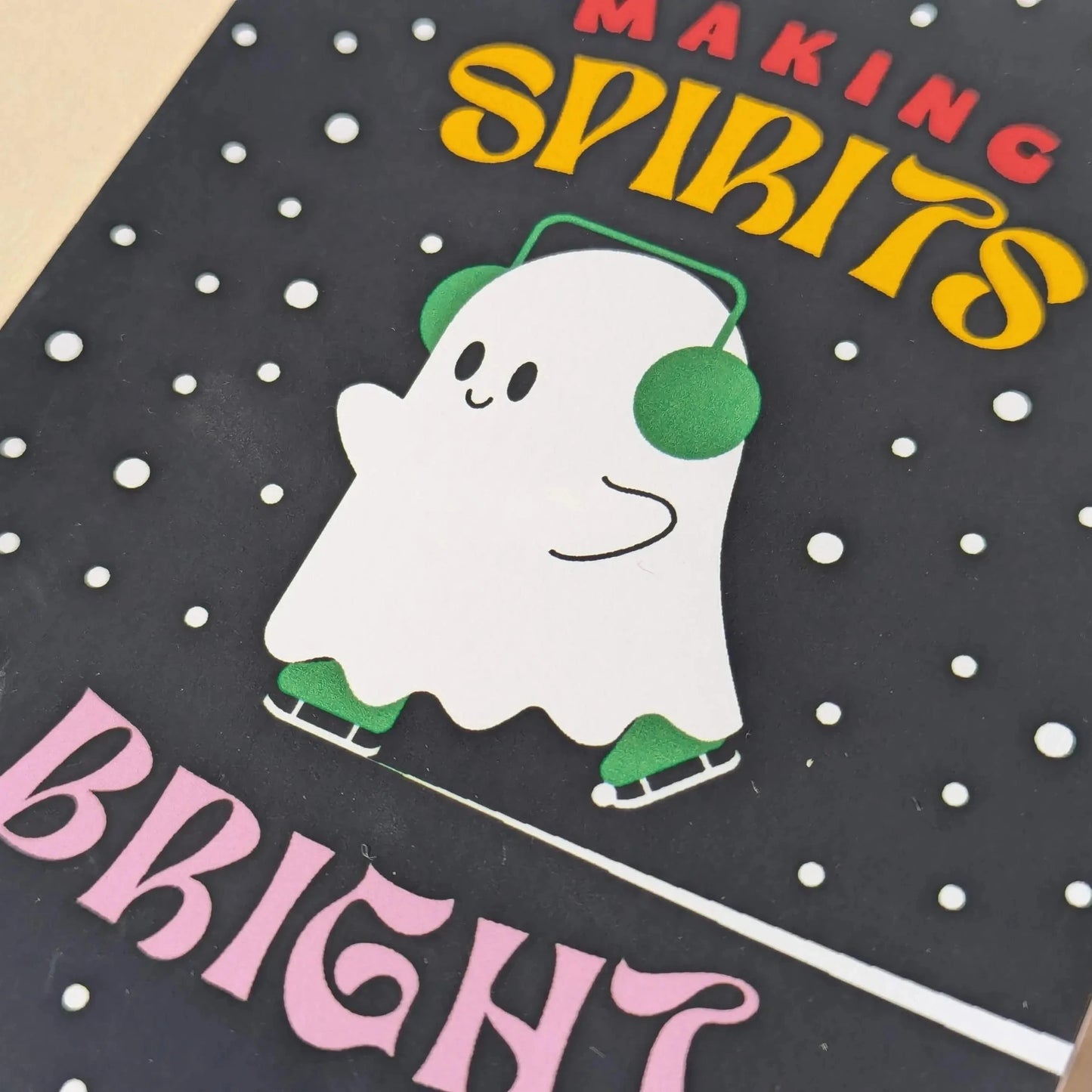 Card with a ghost illustration and text 'Making Spirits Bright' on a polka dot background