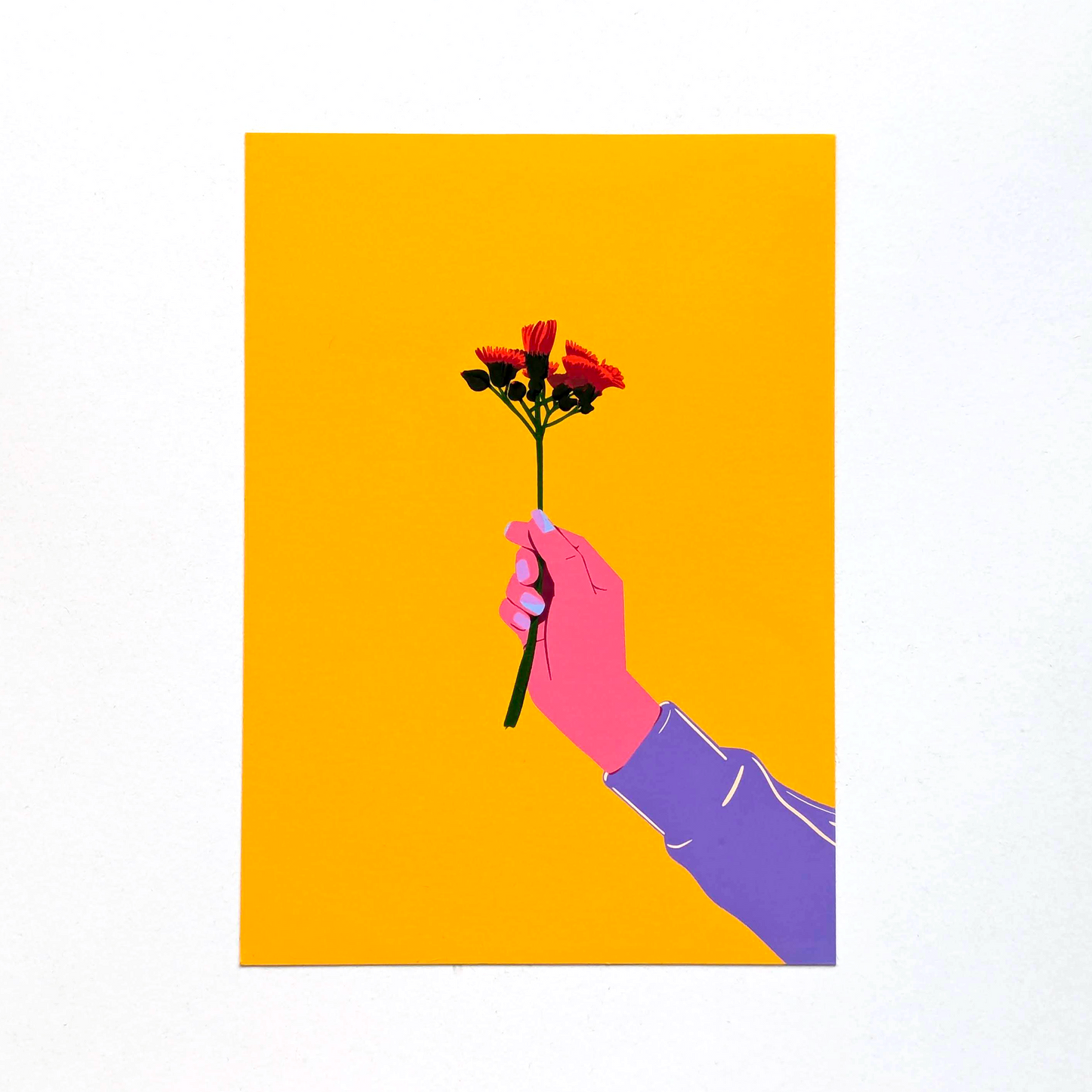 Hand holding a bouquet of flowers against a yellow background