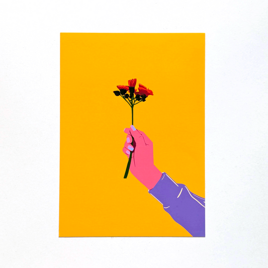 Hand holding a bouquet of flowers against a yellow background
